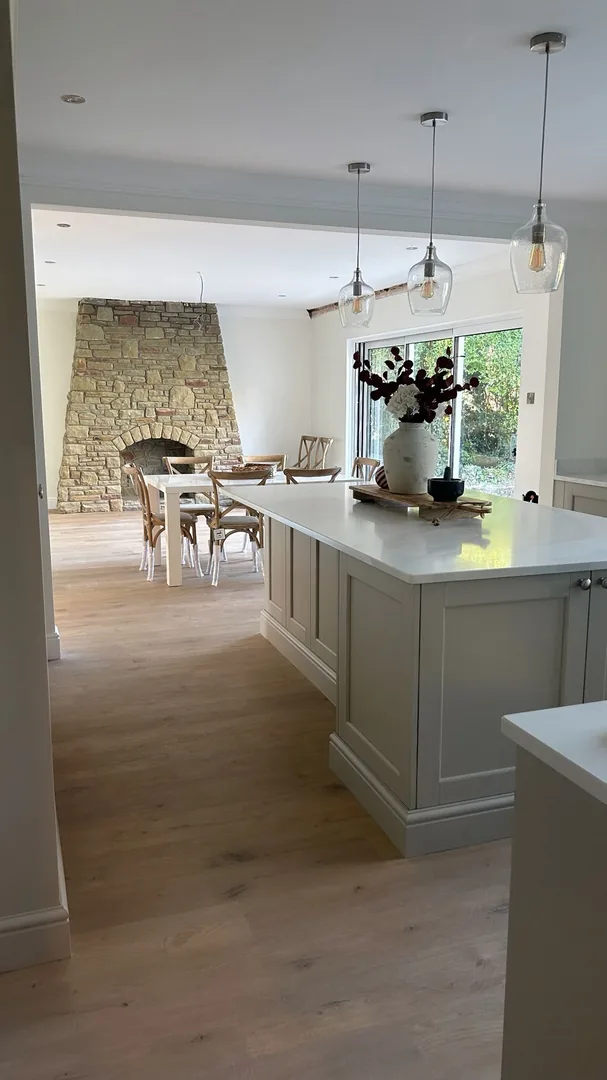 Completed kitchen dining area with stone fireplace and bifold doors by JRD Construction